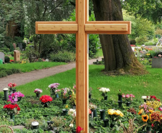 Holzkreuz aus Lärche für ein Urnenfeld – handgefertigtes Grabkreuz mit schlichter Formensprache auf einem gepflegten Friedhof
